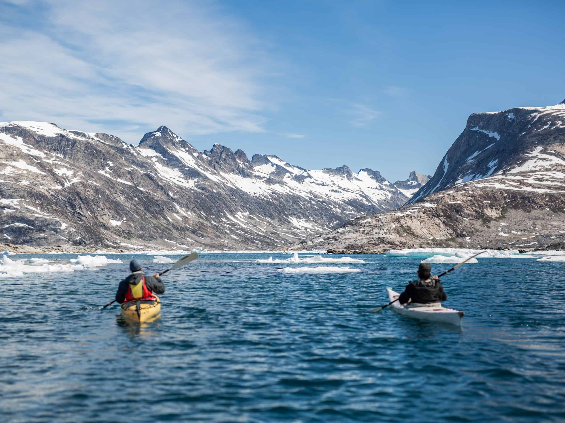 Kayaker paddling among icebergs